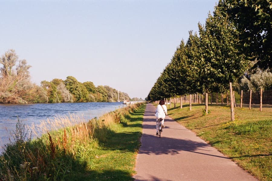 A woman cycling on a road along the Somme